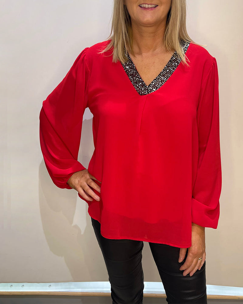 Solid color top with sequins and V-neck