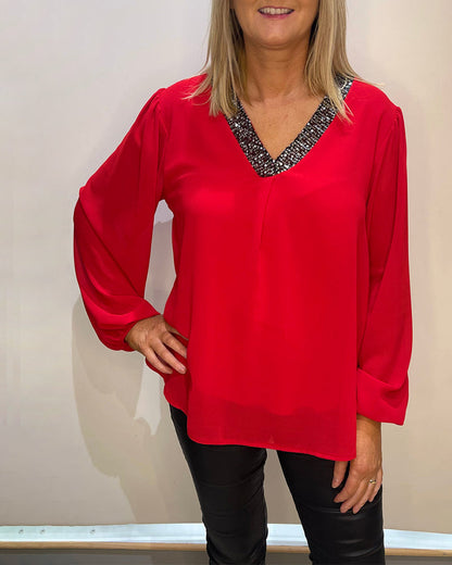 Solid color top with sequins and V-neck
